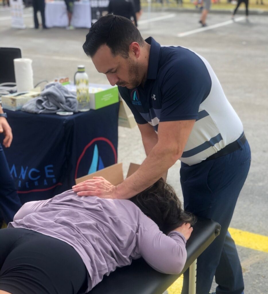 A man giving a massage to a woman at an event.